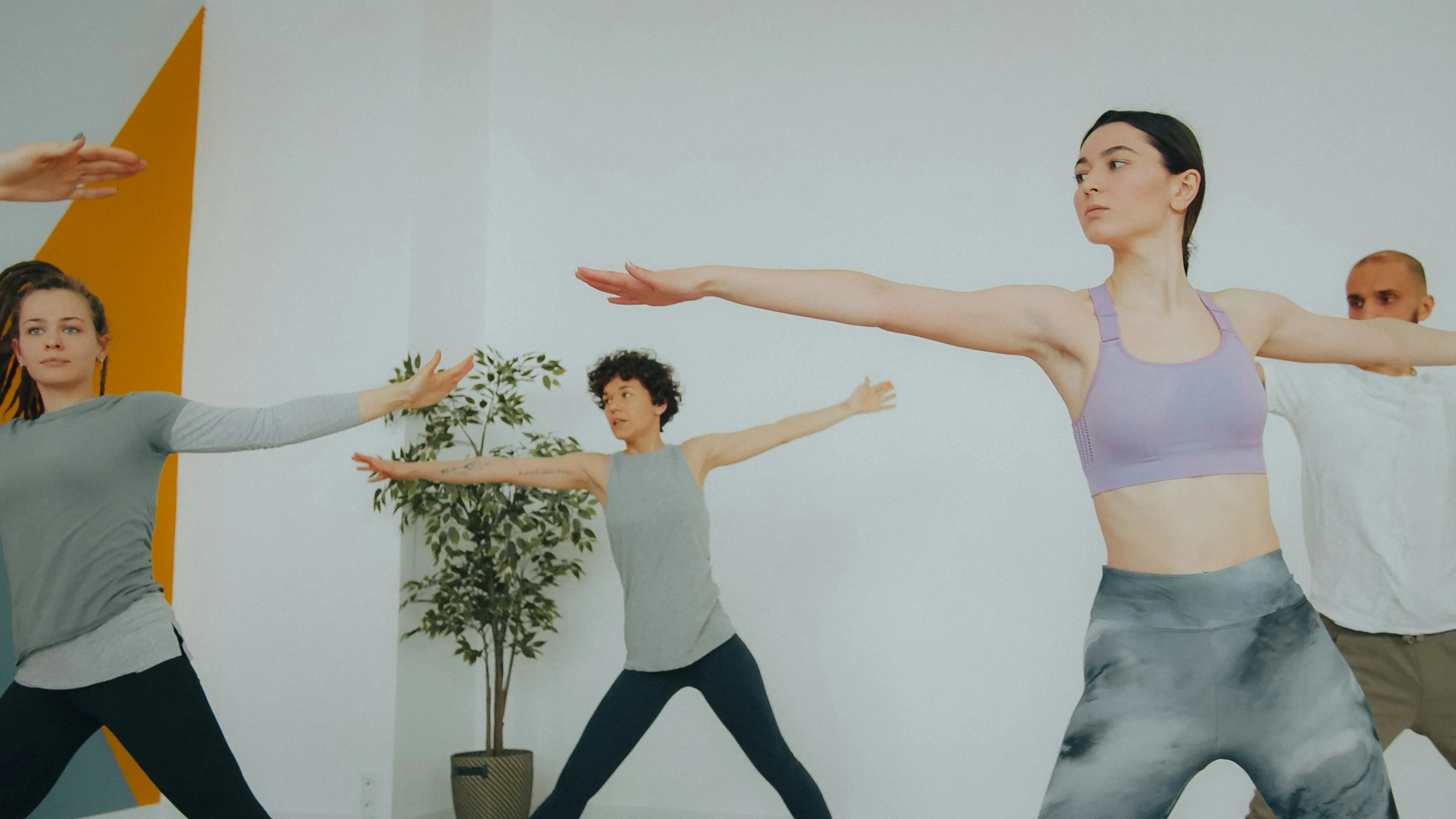Group stretching their arms wide in a bright yoga class